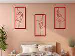 Metal wall art set featuring three minimalist ballerina silhouettes in various elegant dance poses, finished in Manor Red powder coating, mounted on a light peach wall above a bed, adding a graceful and artistic touch to the bedroom.