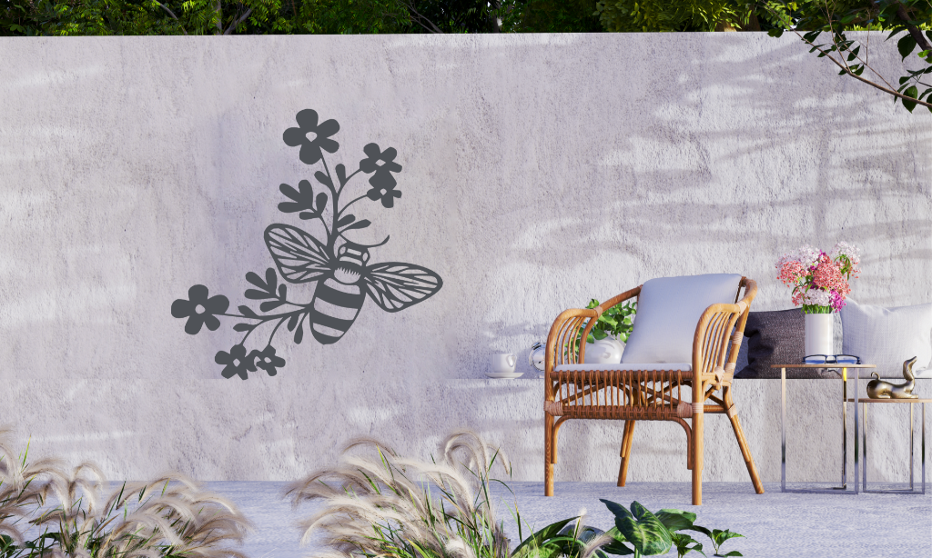 Metal wall art featuring a bee resting on a floral branch, finished in Berry Grey Gloss powder coating, mounted on an outdoor wall, adding a natural and playful touch to garden decor.