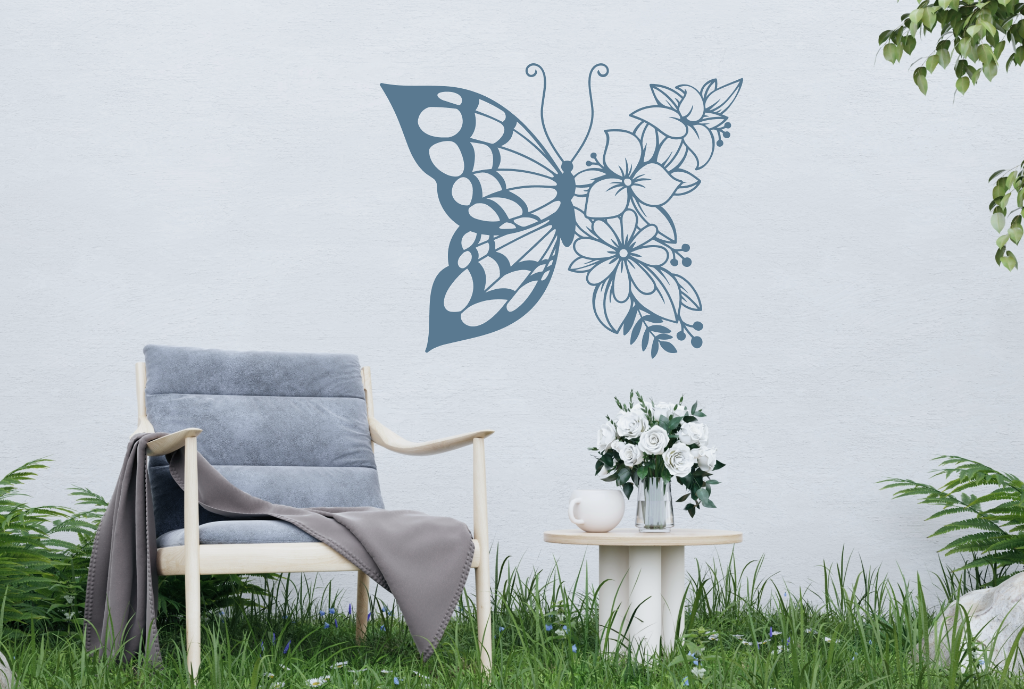 Metal wall art featuring a butterfly design with one wing made of floral patterns, finished in Berry Grey Gloss powder coating, mounted on an outdoor wall, adding a whimsical and nature-inspired touch to a cozy garden seating area.