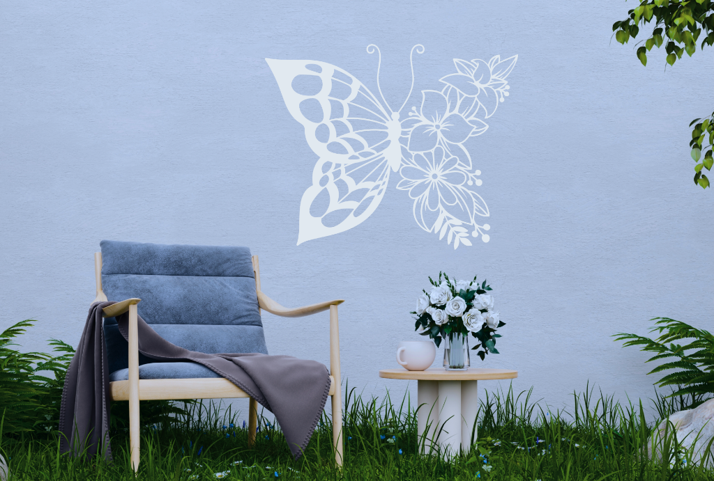 Metal wall art featuring a butterfly design with one wing made of floral patterns, finished in Bright White Gloss powder coating, mounted on an outdoor wall, adding a whimsical and nature-inspired touch to a cozy garden seating area.