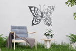 Metal wall art featuring a butterfly design with one wing made of floral patterns, finished in Berry Grey Gloss powder coating, mounted on an outdoor wall, adding a whimsical and nature-inspired touch to a cozy garden seating area.