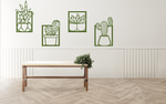 Metal wall art set featuring four distinct cactus designs in minimalist frames, finished in Mistletoe powder coating, creating a modern, playful touch to a neutral-toned interior space with a light wooden bench and soft lighting.