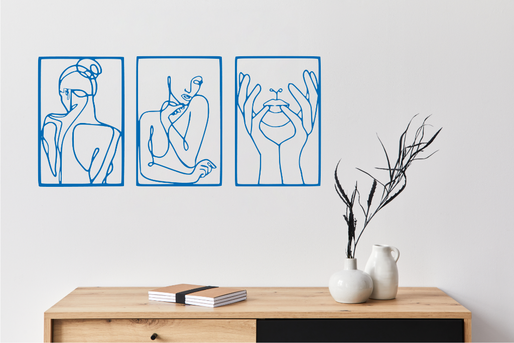 Metal wall art set featuring three minimalist line-drawing silhouettes of feminine figures in graceful poses, finished in Blaze Blue Gloss powder coating, mounted on a white wall above a natural wood console, adding an elegant and artistic touch to modern interiors.