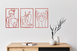 Metal wall art set featuring three minimalist line-drawing silhouettes of feminine figures in graceful poses, finished in Signal Red powder coating, mounted on a white wall above a natural wood console, adding an elegant and artistic touch to modern interiors.