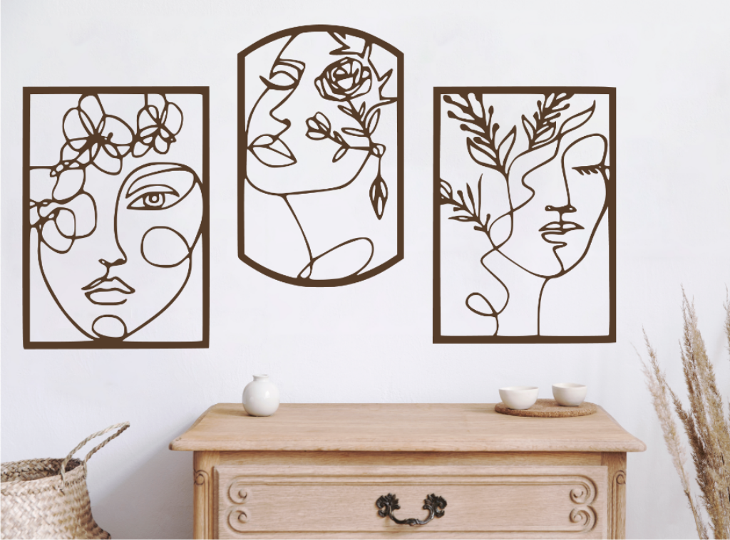 Set of three decorative metal wall art pieces, each featuring an abstract feminine face intertwined with floral elements, finished in Rust Patina powder coating. The artwork is displayed on a white wall above a wooden chest of drawers, adding a modern and artistic touch to the room.