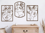 Set of three decorative metal wall art pieces, each featuring an abstract feminine face intertwined with floral elements, finished in Rust Patina powder coating. The artwork is displayed on a white wall above a wooden chest of drawers, adding a modern and artistic touch to the room.