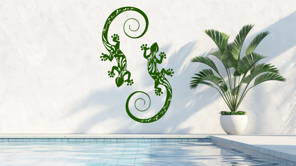 Metal wall art featuring two geckos with intricate detailing on their bodies, finished in Mistletoe powder coating, mounted on a light wall near a poolside, adding a tropical and playful touch to the outdoor space.