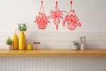 Metal wall art featuring three hanging planters with intricate plant designs, finished in Signal Red powder coating, mounted on a kitchen wall. The piece brings a natural and modern aesthetic to the space, complementing the vibrant yellow decor elements on the counter below.