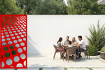 Vibrant metal privacy screen featuring circular patterns, coated in Signal Red, perfect for adding energy and privacy to outdoor areas