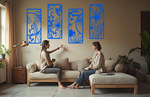 A four-piece metal wall art set from the 'Lush Escape Collection,' featuring intricate nature-inspired designs of leaves and flowers, finished in Blaze Blue Gloss powder coating. The artwork is mounted on a living room wall above a neutral-toned sofa, adding a calming and organic touch to the space.