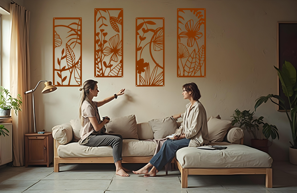 A four-piece metal wall art set from the 'Lush Escape Collection,' featuring intricate nature-inspired designs of leaves and flowers, finished in Rust Patina powder coating. The artwork is mounted on a living room wall above a neutral-toned sofa, adding a calming and organic touch to the space