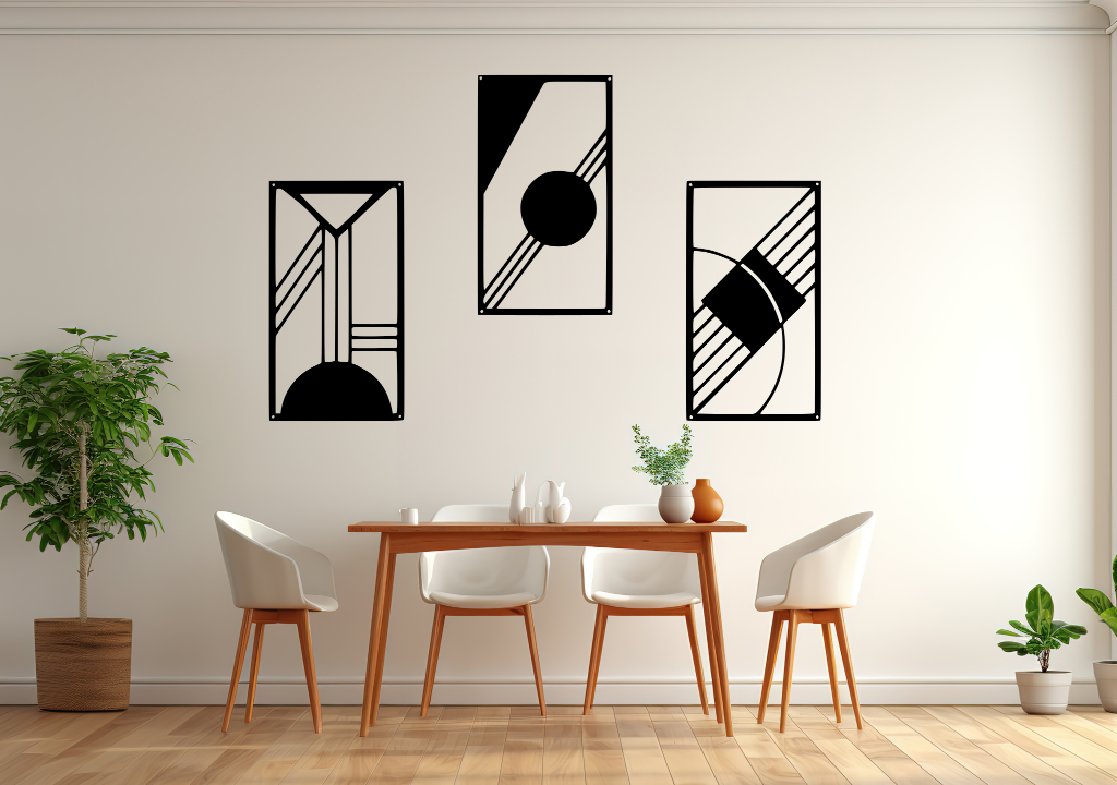 A three-piece minimalist metal wall art set from the 'Serenity in Simplicity' collection, featuring geometric designs of clean lines and abstract shapes, finished in Night Sky Matt Black powder coating. The artwork is mounted on a dining room wall above a simple wooden table with white chairs, creating a modern and calming aesthetic.