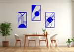 A three-piece minimalist metal wall art set from the 'Serenity in Simplicity' collection, featuring geometric designs of clean lines and abstract shapes, finished in Blaze Blue Gloss powder coating. The artwork is mounted on a dining room wall above a simple wooden table with white chairs, creating a modern and calming aesthetic.