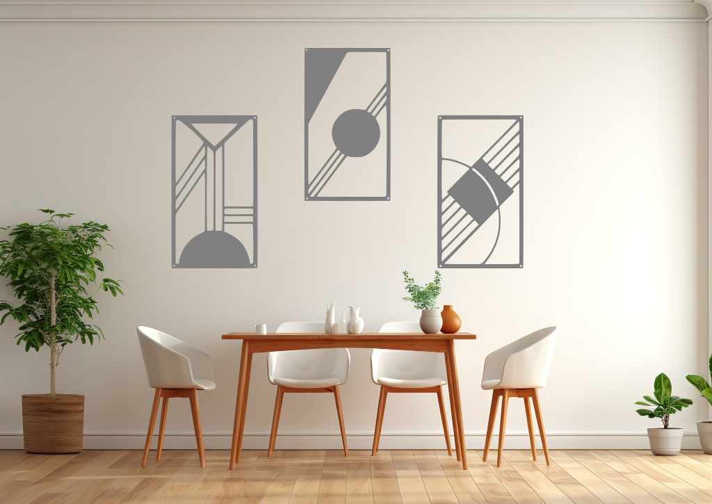 A three-piece minimalist metal wall art set from the 'Serenity in Simplicity' collection, featuring geometric designs of clean lines and abstract shapes, finished in Berry Grey Gloss powder coating. The artwork is mounted on a dining room wall above a simple wooden table with white chairs, creating a modern and calming aesthetic.