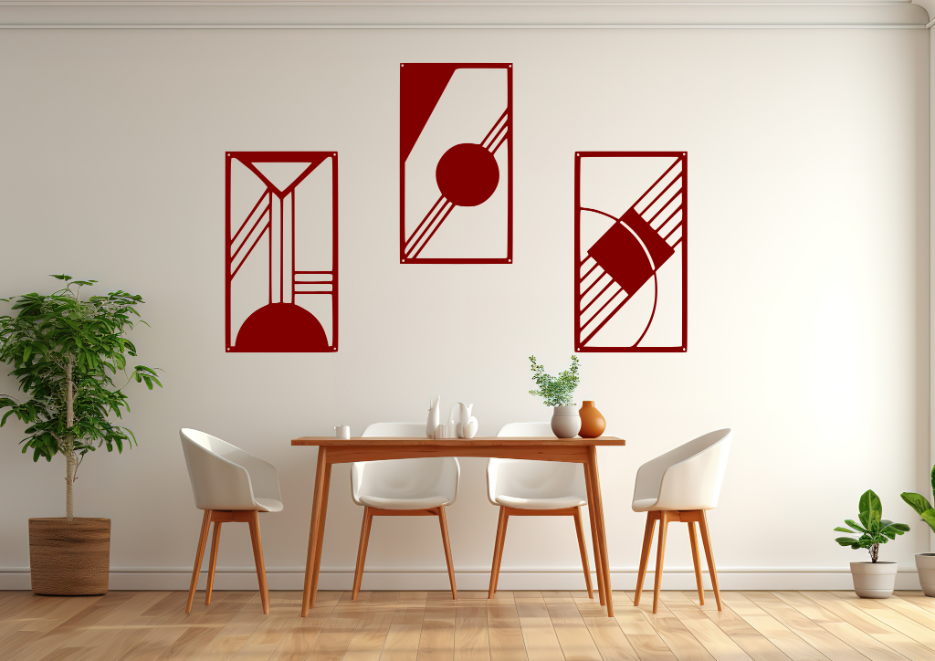 A three-piece minimalist metal wall art set from the 'Serenity in Simplicity' collection, featuring geometric designs of clean lines and abstract shapes, finished in Manor Red powder coating. The artwork is mounted on a dining room wall above a simple wooden table with white chairs, creating a modern and calming aesthetic