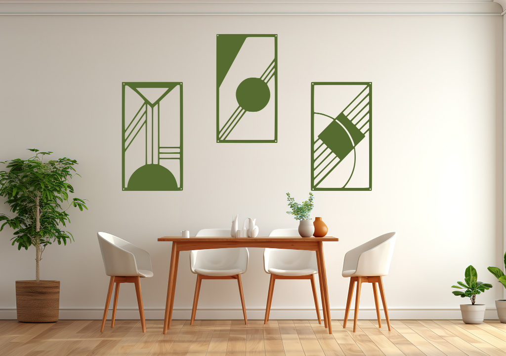 A three-piece minimalist metal wall art set from the 'Serenity in Simplicity' collection, featuring geometric designs of clean lines and abstract shapes, finished in Mistletoe powder coating. The artwork is mounted on a dining room wall above a simple wooden table with white chairs, creating a modern and calming aesthetic.