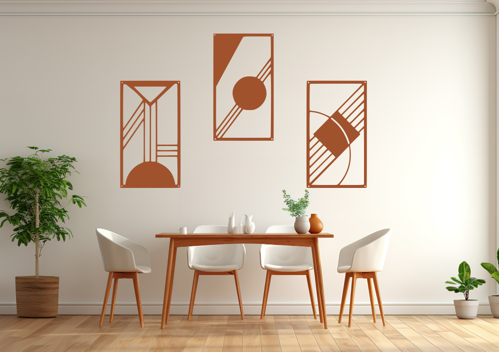 A three-piece minimalist metal wall art set from the 'Serenity in Simplicity' collection, featuring geometric designs of clean lines and abstract shapes, finished in Rust Patina powder coating. The artwork is mounted on a dining room wall above a simple wooden table with white chairs, creating a modern and calming aesthetic