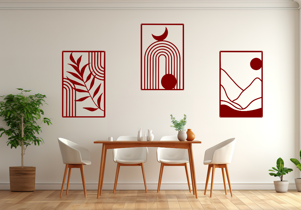 A three-piece minimalist geometric metal wall art set featuring abstract shapes, including a leaf design, a rainbow with moon and sun, and a mountain landscape, all finished in Manor Red powder coating. The artwork is mounted on a dining room wall above a simple wooden table with white chairs, bringing a modern and artistic touch to the space.