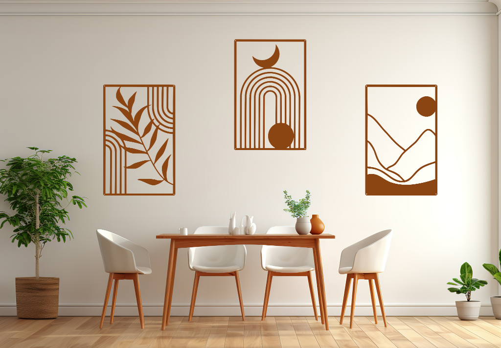 A three-piece minimalist geometric metal wall art set featuring abstract shapes, including a leaf design, a rainbow with moon and sun, and a mountain landscape, all finished in Rust Patina powder coating. The artwork is mounted on a dining room wall above a simple wooden table with white chairs, bringing a modern and artistic touch to the space.