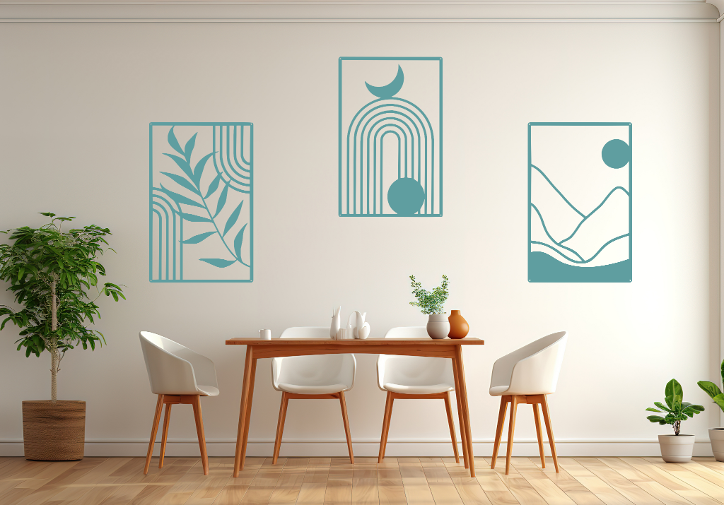 A three-piece minimalist geometric metal wall art set featuring abstract shapes, including a leaf design, a rainbow with moon and sun, and a mountain landscape, all finished in Wedgwood Satin powder coating. The artwork is mounted on a dining room wall above a simple wooden table with white chairs, bringing a modern and artistic touch to the space.