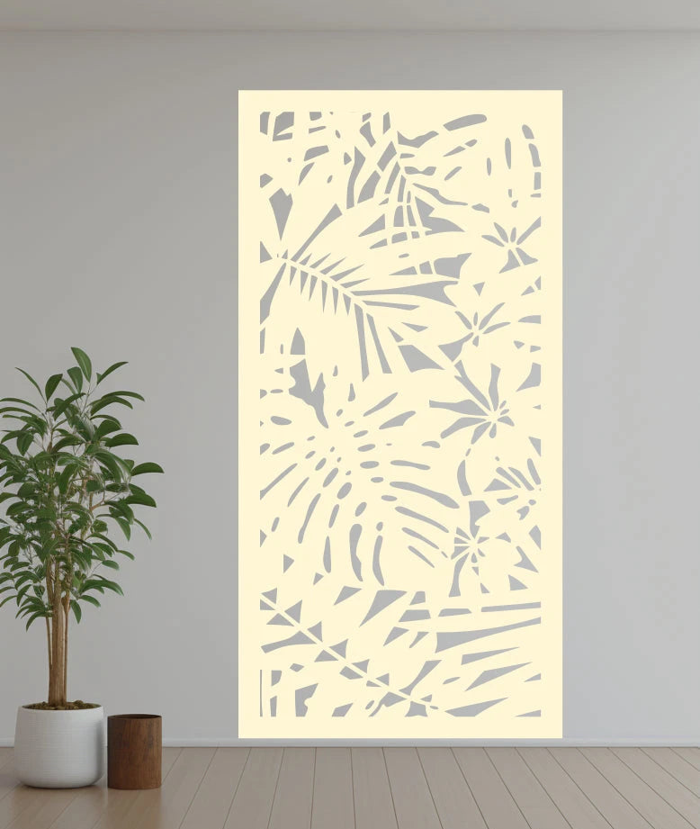 Metal privacy screen titled 'Nature,' featuring a detailed cutout of abstract botanical elements, finished in Canola Cream powder coating. The screen is mounted on an indoor white wall, adding a soft and warm glow to the room’s ambiance