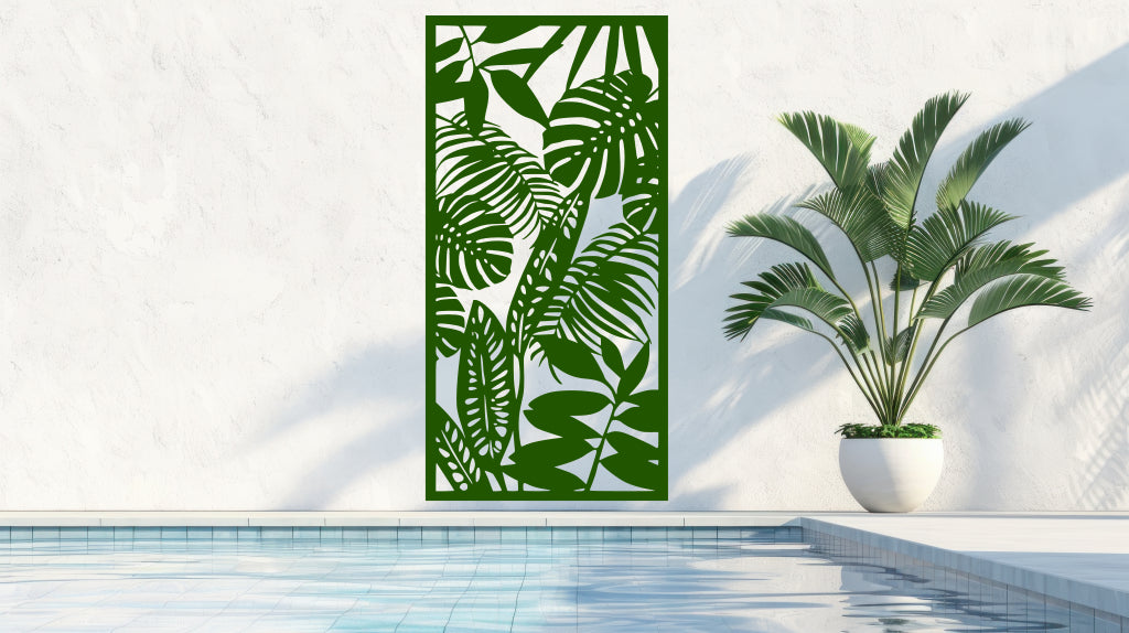 The 'Rainforest Leaves' metal privacy screen featuring an intricate design of tropical leaves, finished in Mistletoe powder coating. The screen is mounted on a white wall near a serene poolside area with a large potted plant, adding a natural and stylish touch to the outdoor space.