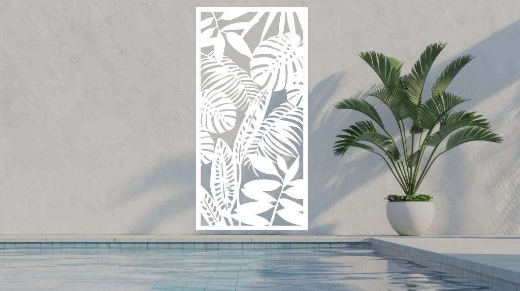 The 'Rainforest Leaves' metal privacy screen featuring an intricate design of tropical leaves, finished in Bright White Gloss powder coating. The screen is mounted on a white wall near a serene poolside area with a large potted plant, adding a clean and stylish touch to the outdoor space.